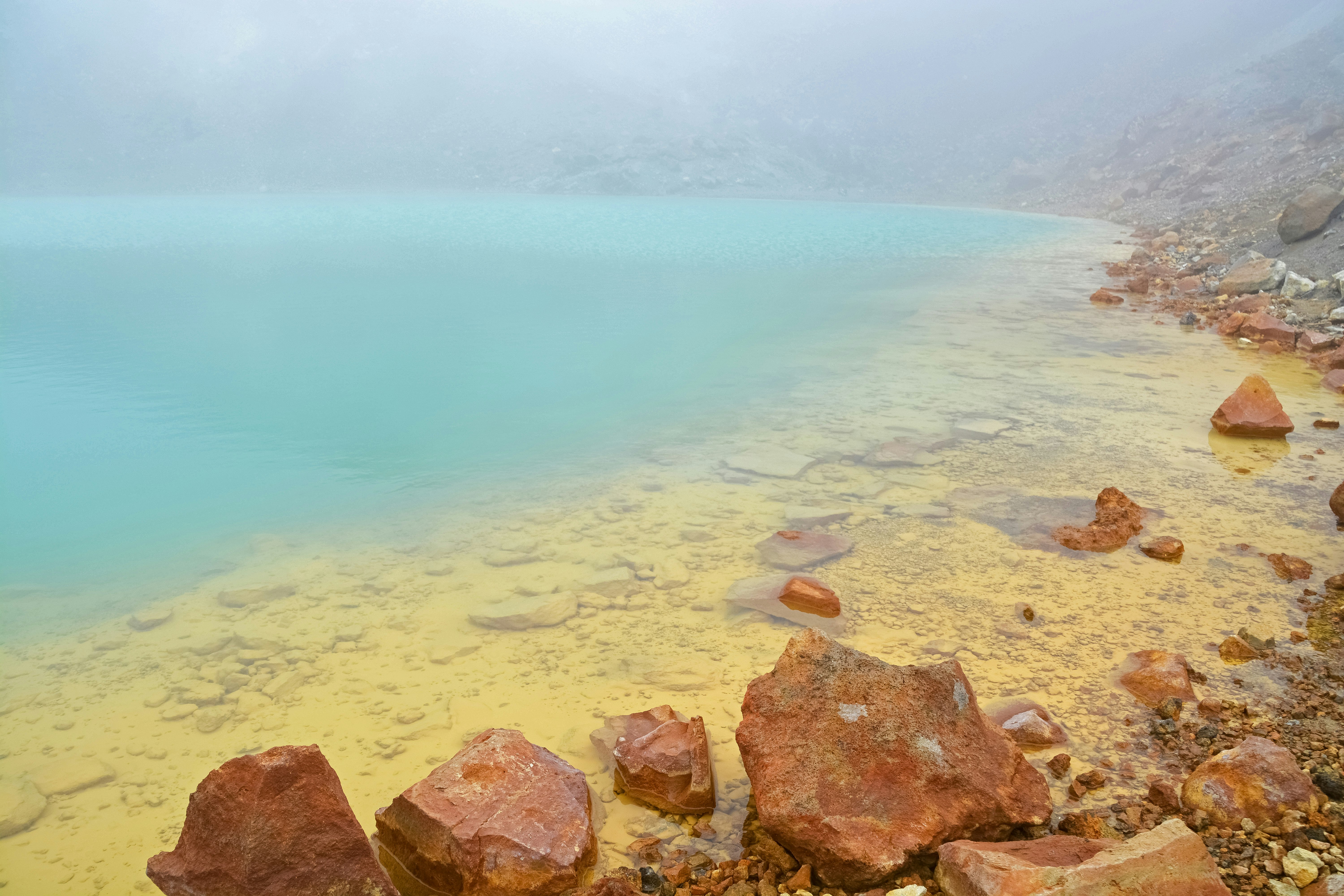 brown and gray rocks beside body of water