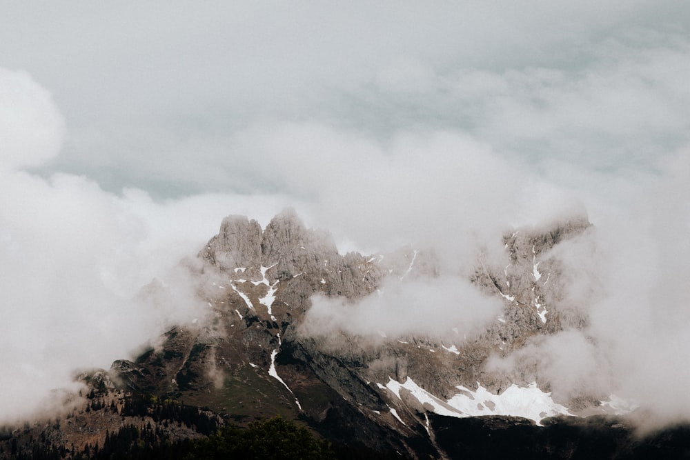 white clouds over snow covered mountain