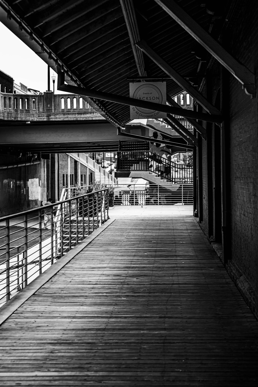 grayscale photo of a wooden bridge