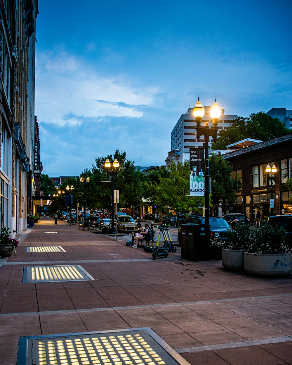 people walking on sidewalk near buildings during night time