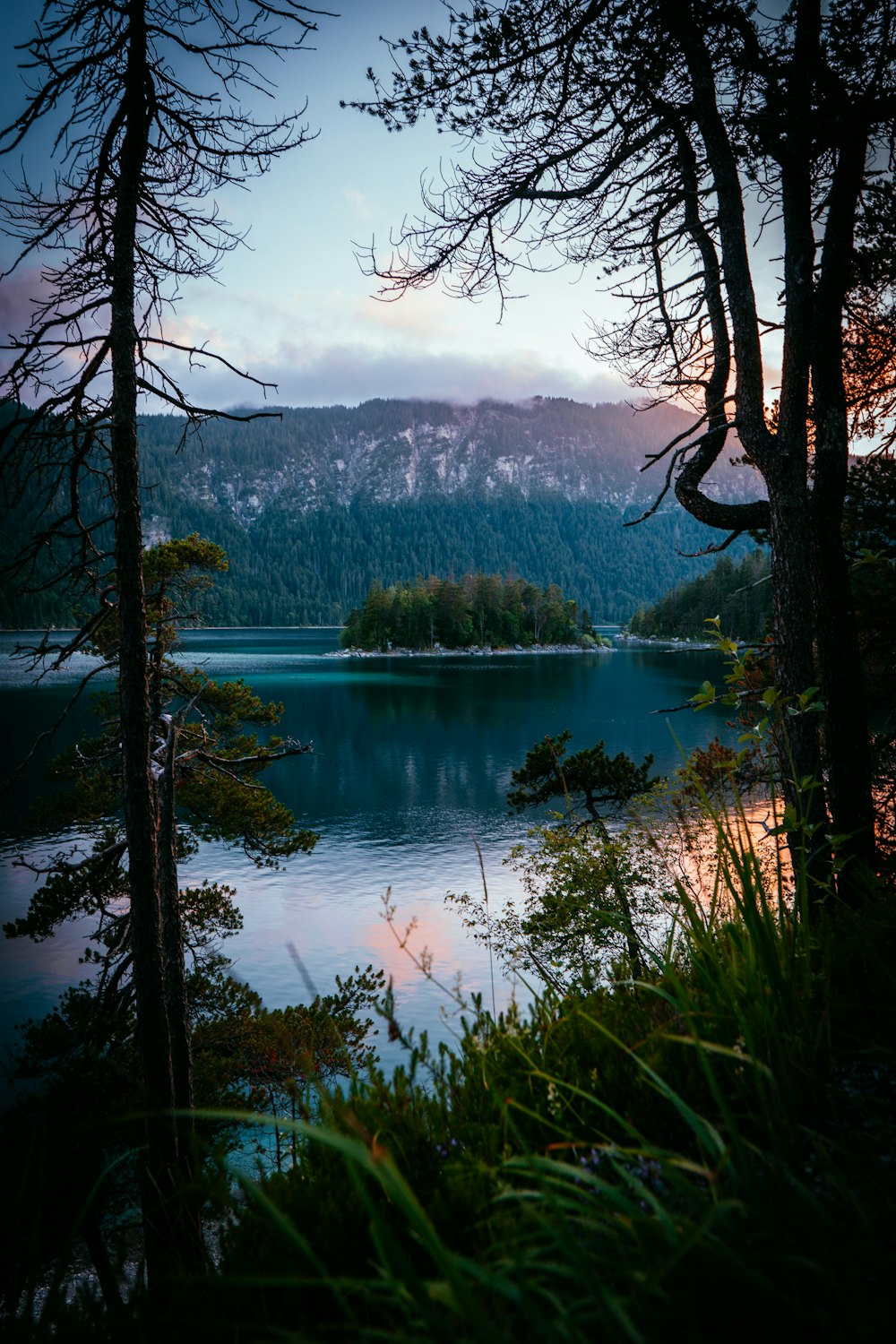 lake surrounded by trees and mountains during daytime