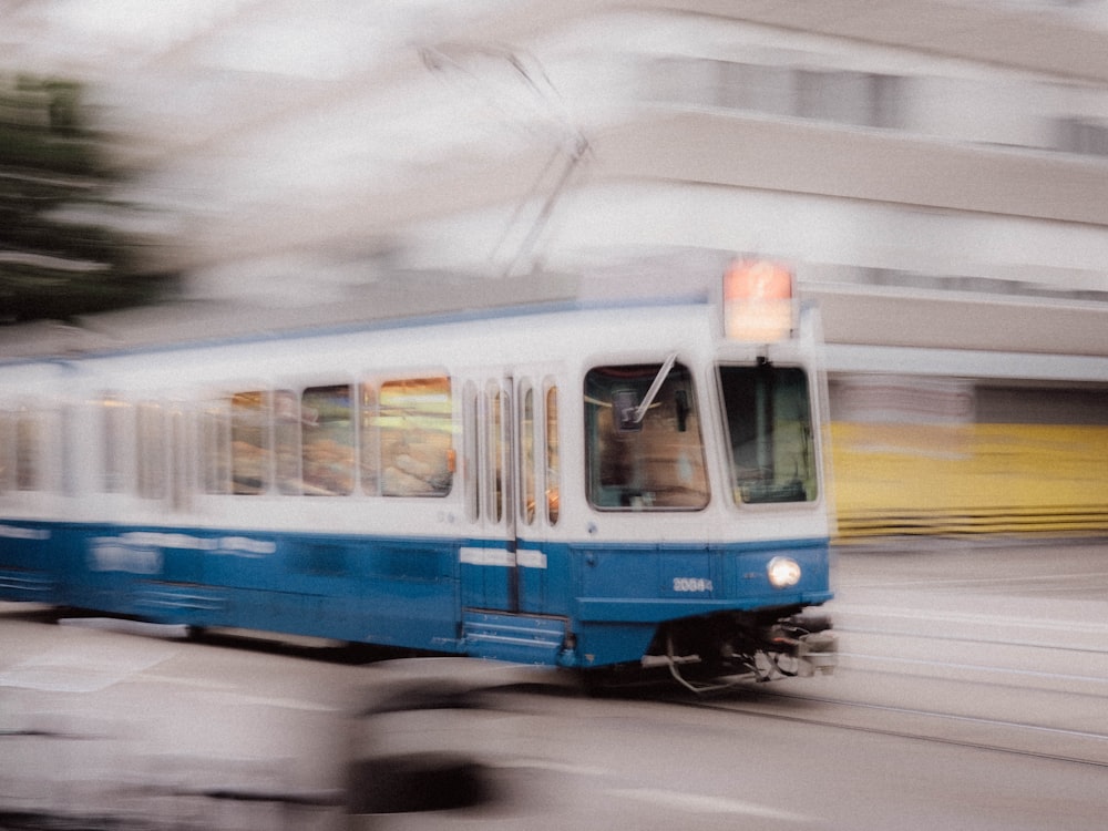 blue and white train on rail road during daytime