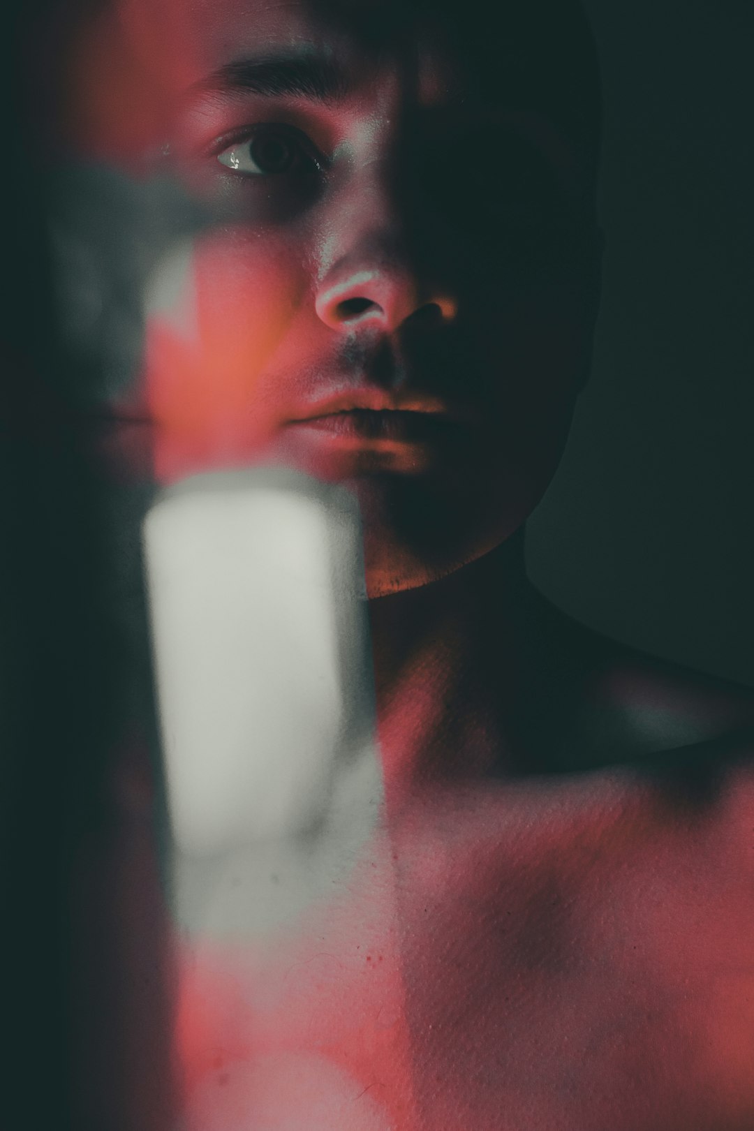 topless man holding white plastic bottle