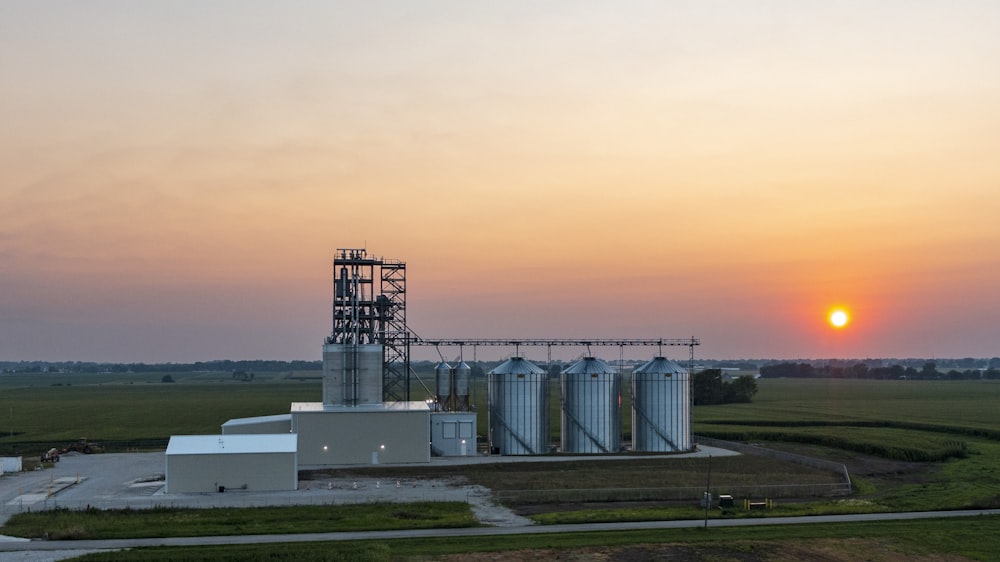 white and gray factory under orange sky