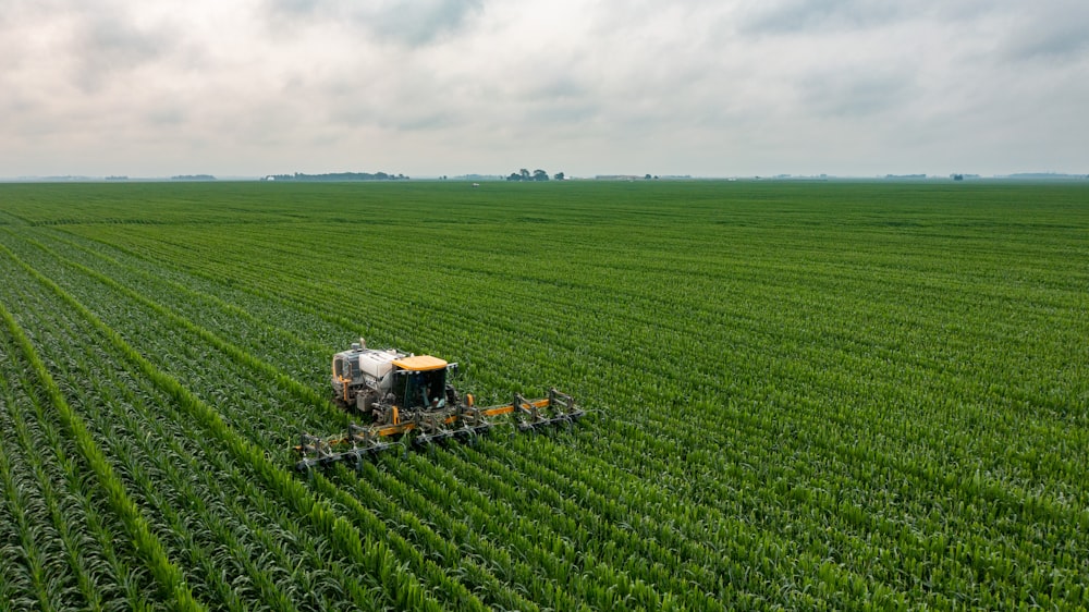 yellow and black tractor on green grass field during daytime