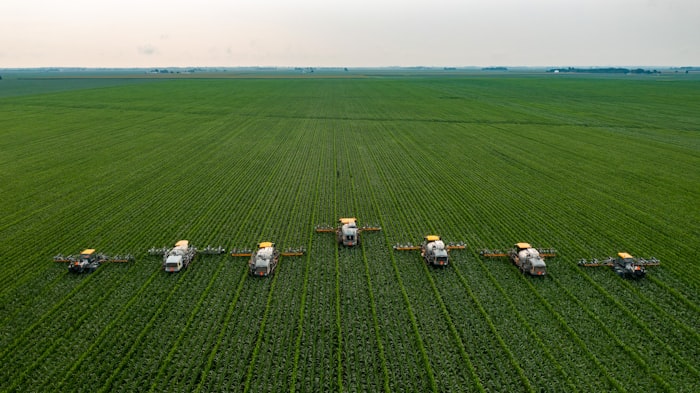 Tractor harvesting a field, aerial view