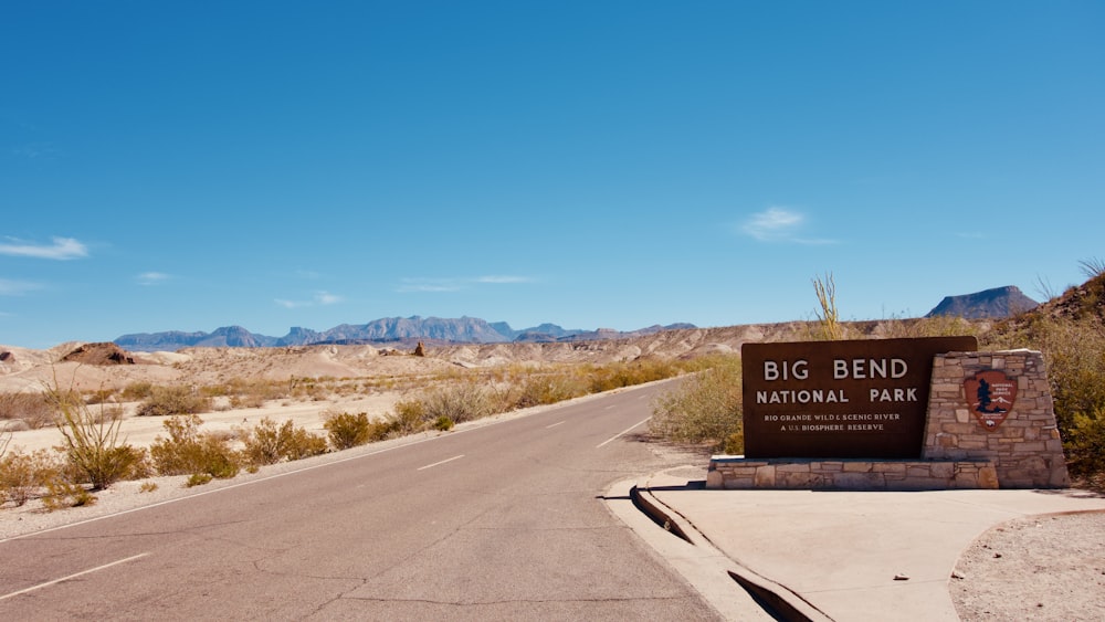 brown and black wooden signage on gray asphalt road during daytime