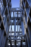 Steel structural beams arranged outdoors under a clear blue sky.