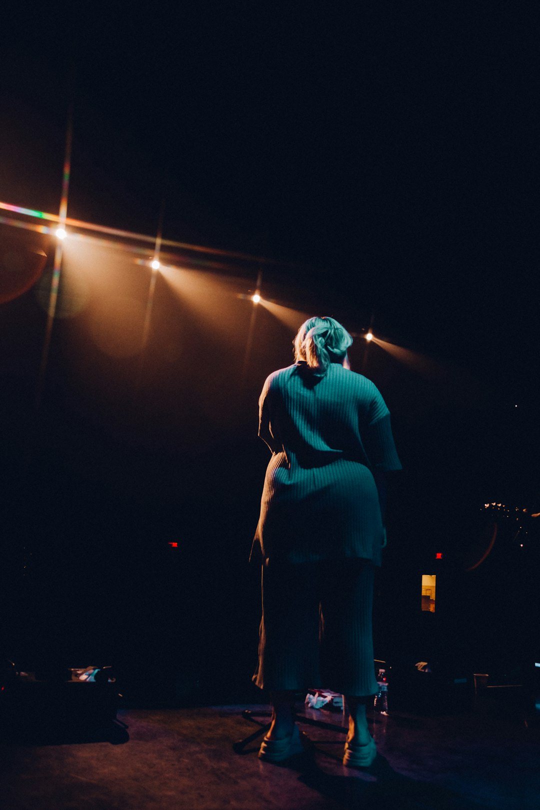 woman in blue long sleeve shirt standing on stage