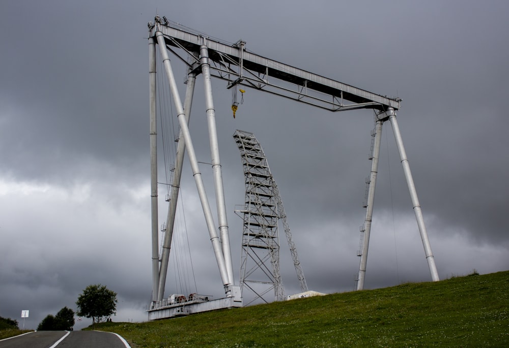 white metal tower on green grass field under white sky during daytime