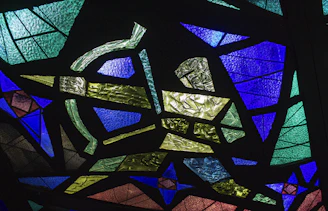 Modern stained glass panel featuring geometric shapes in vibrant blues and reds.