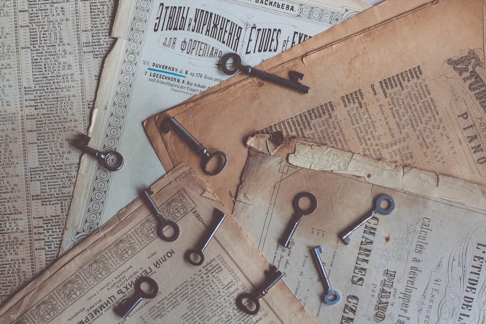 a pile of old newspaper with a bunch of keys on top of it