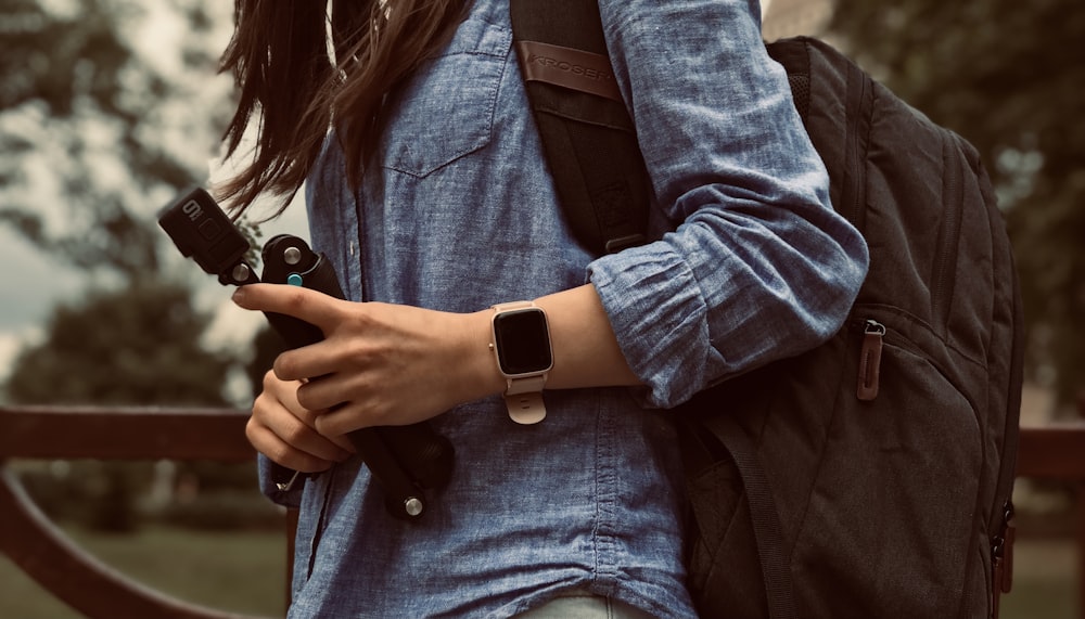 woman in blue denim jacket and blue denim jacket holding black dslr camera