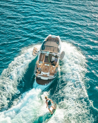 man in blue shorts on white and brown boat during daytime