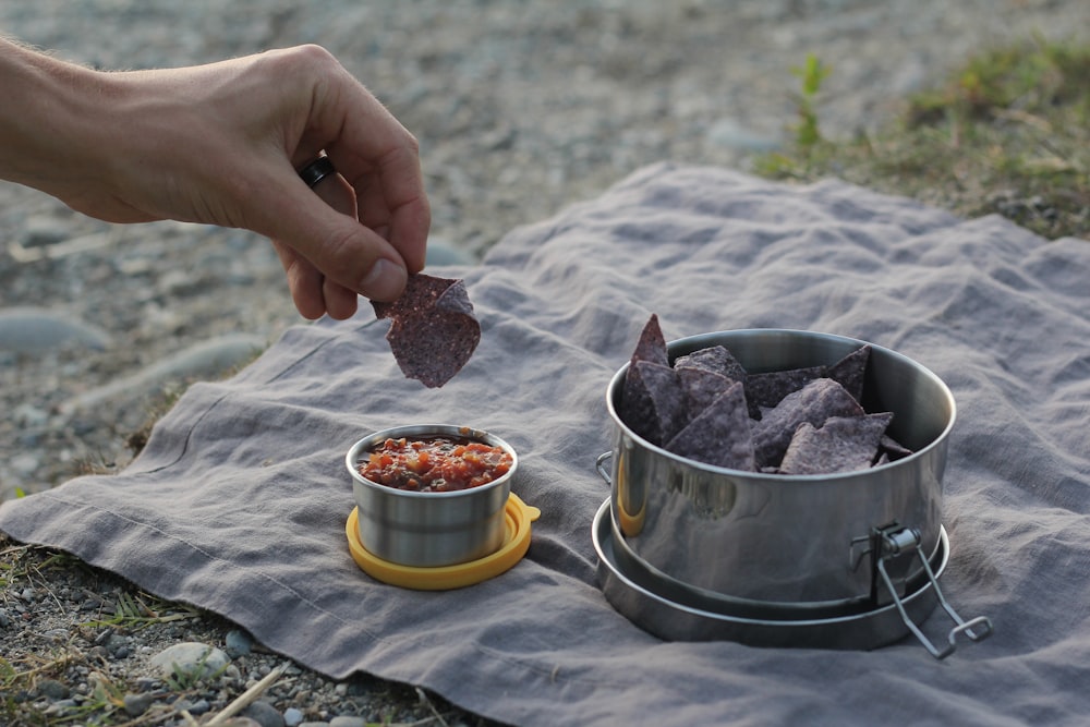 person holding stainless steel bowl with food