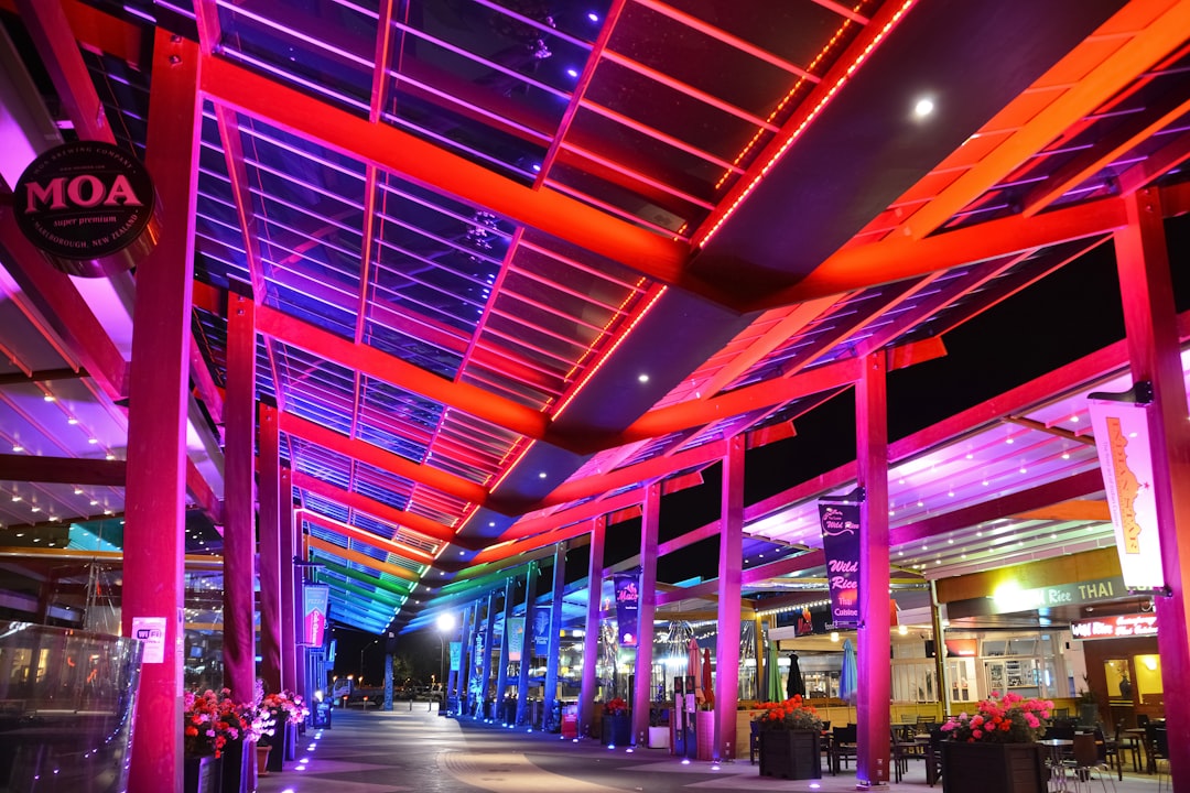 people walking inside building with red ceiling