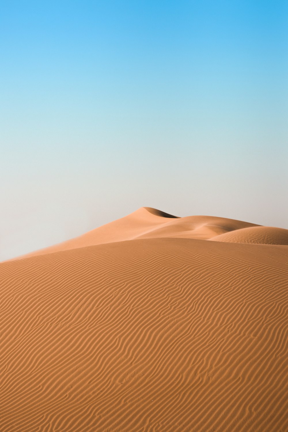 brauner Sand unter blauem Himmel tagsüber