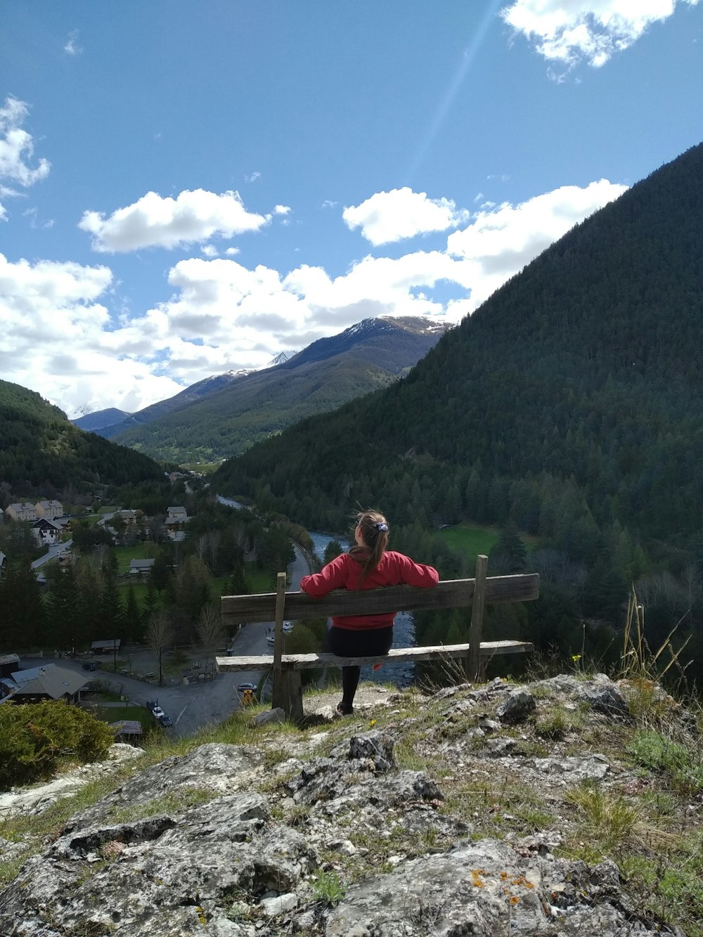 man and woman sitting on bench near lake during daytime