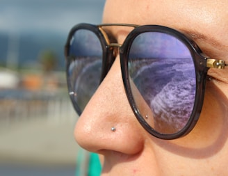 Close-up of trendy sunglasses reflecting a sunny outdoor scene.