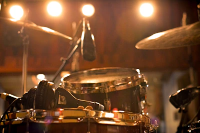 Warm, intimate shot of a small group drum lesson in a cozy, authentic music room.