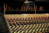 Audio mixing console with colorful control lights in a sleek, clean studio setting.