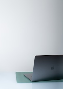 A sleek laptop displaying a dark mode website design on a modern desk.