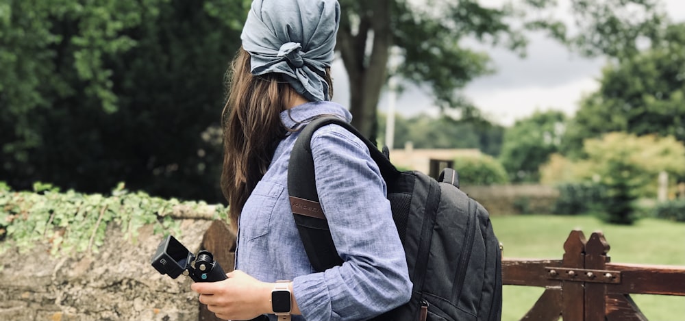 woman in gray hoodie holding black dslr camera