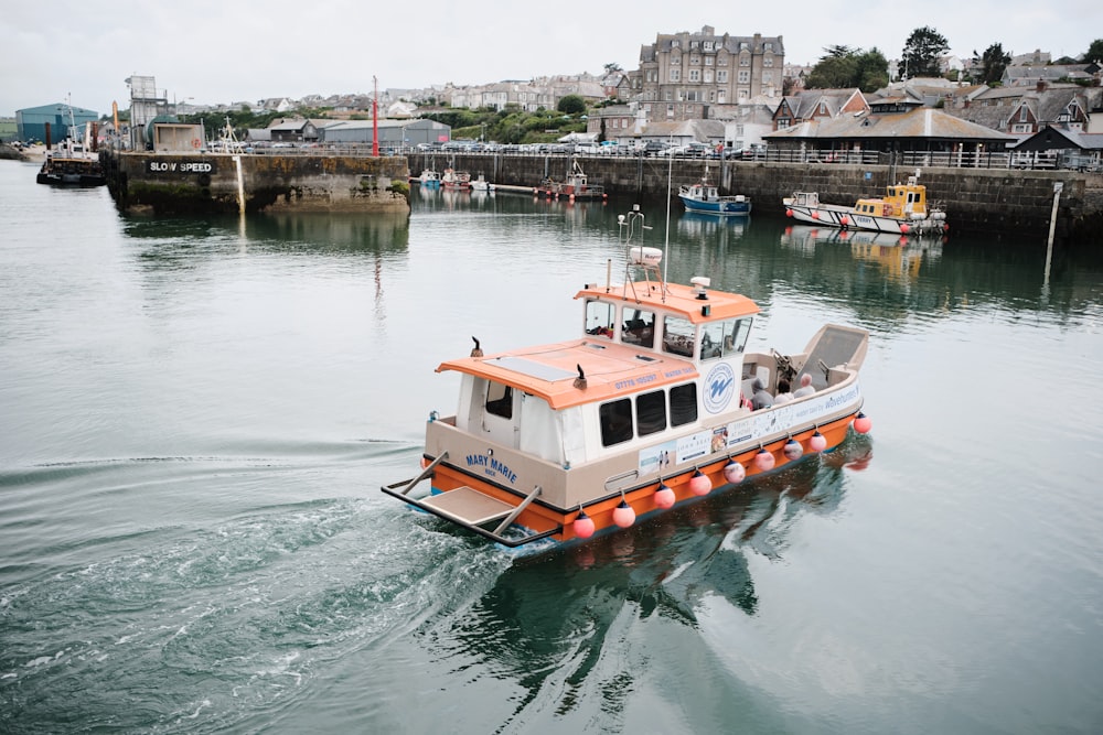 white and orange boat on water during daytime