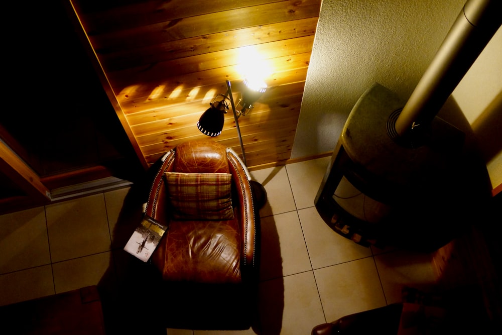 fauteuil en cuir marron à côté d’une armoire en bois marron