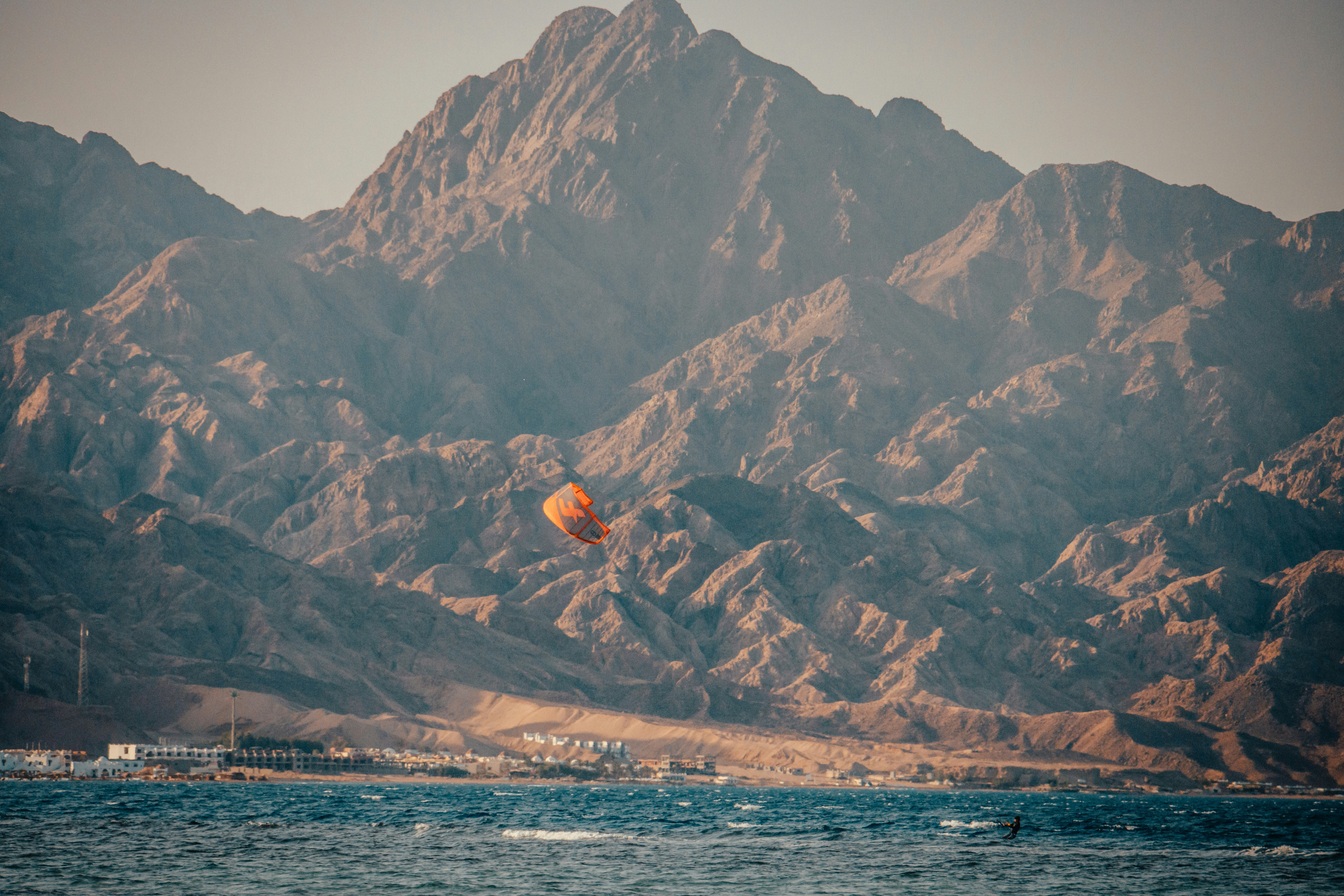 Brown and white mountains near body of water during daytime photo ...