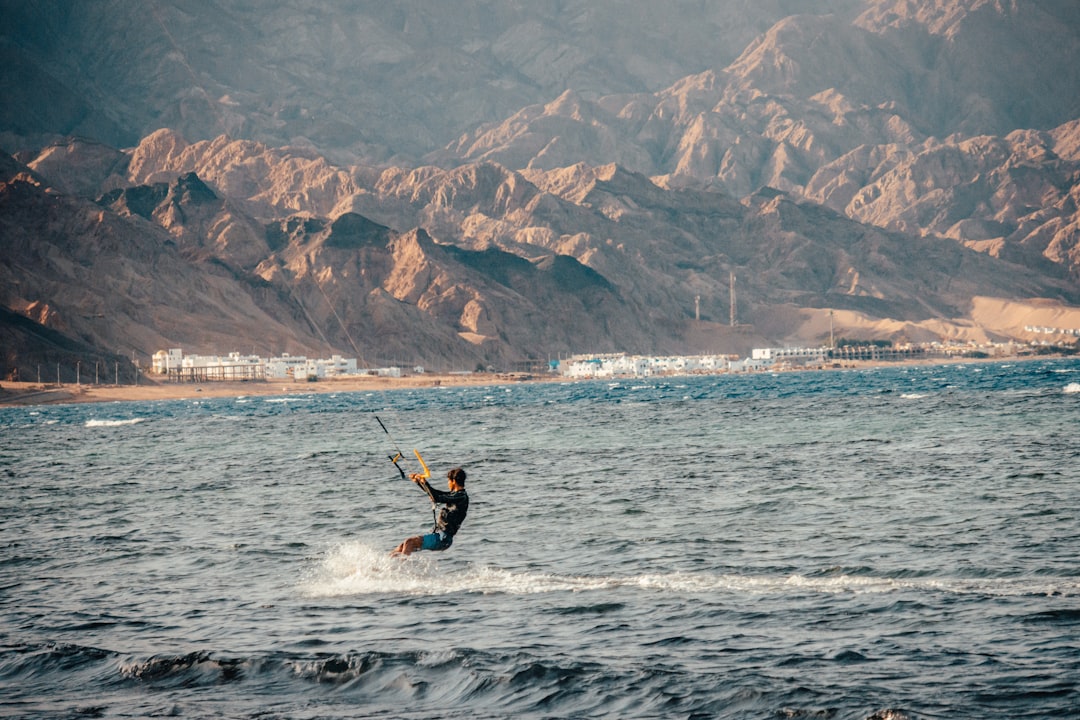 man in black wetsuit surfing on sea during daytime