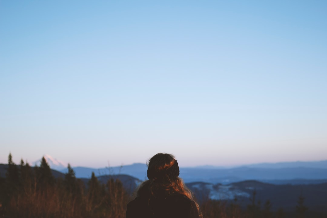 person in black jacket standing on mountain during daytime