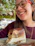 A happy woman enjoying a gluten-free, sugar-free dessert in a cozy kitchen.