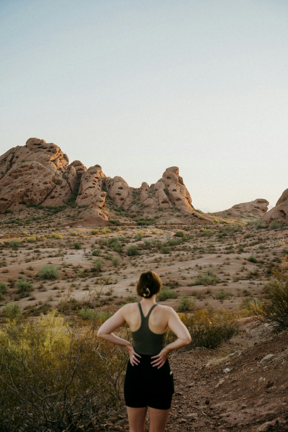 woman in black tank top standing on green grass field during daytime