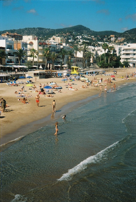 A sunny beach area with families lounging and playing.