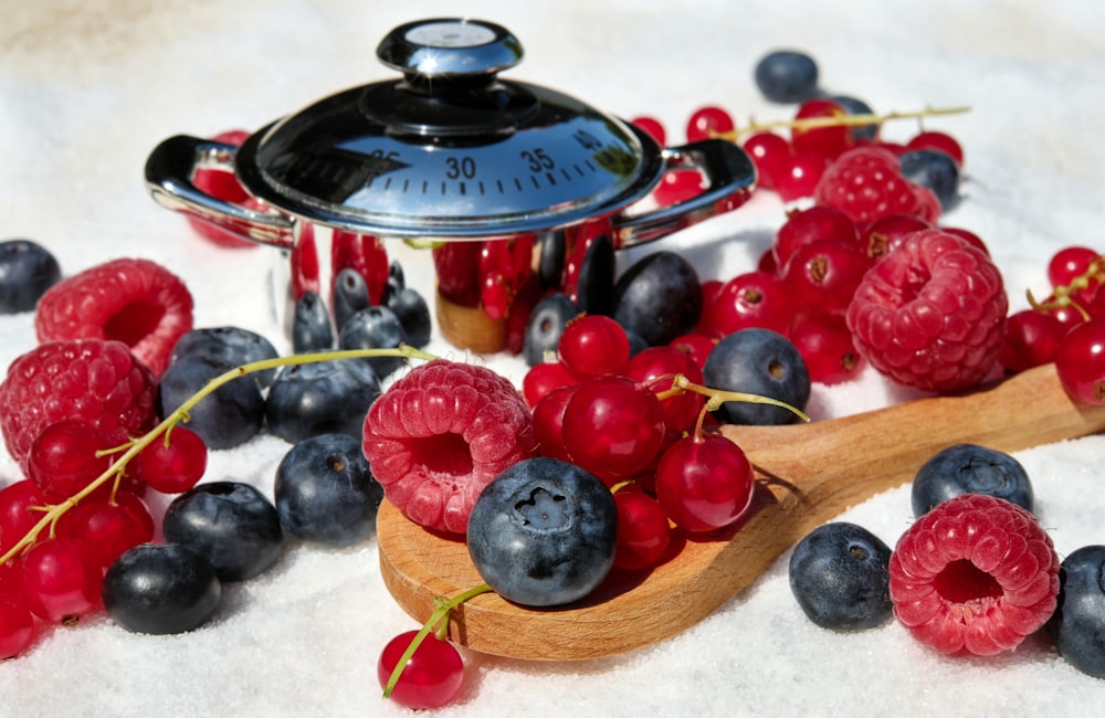 black and red berries on brown wooden spoon