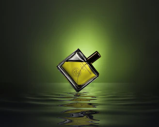 gold colored and black perfume bottle on water