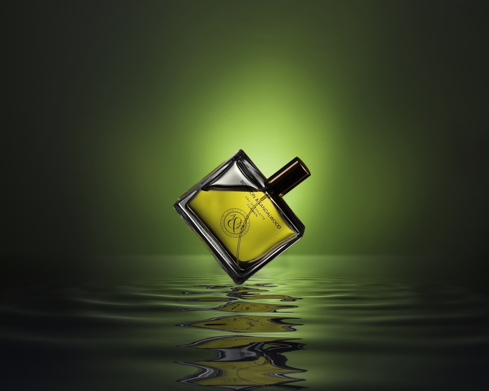 gold colored and black perfume bottle on water