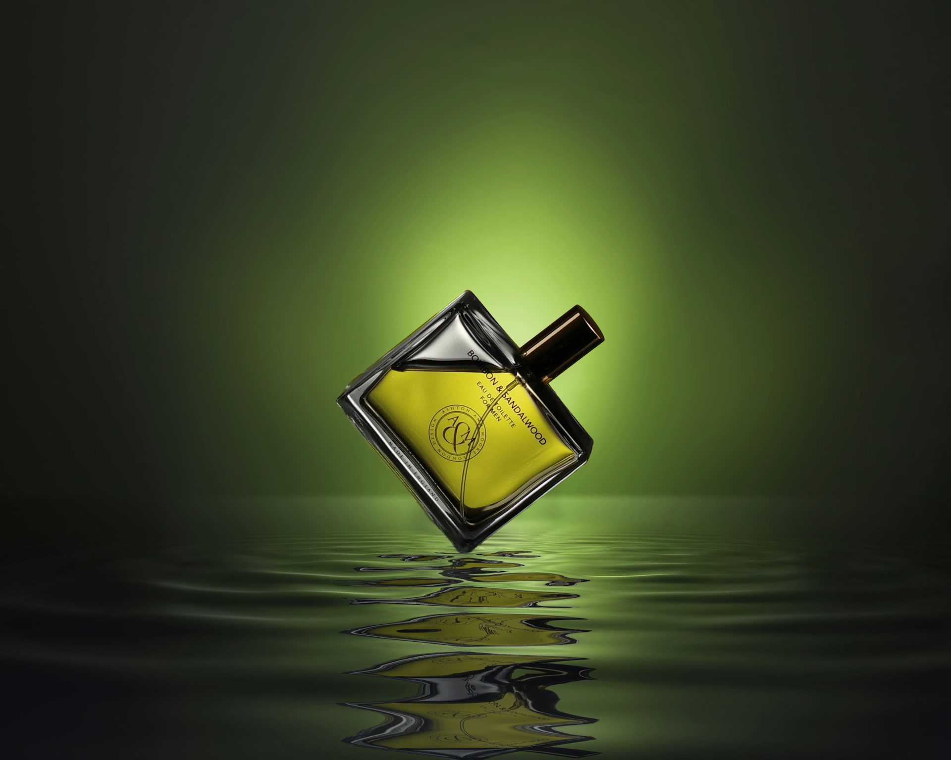 gold colored and black perfume bottle on water