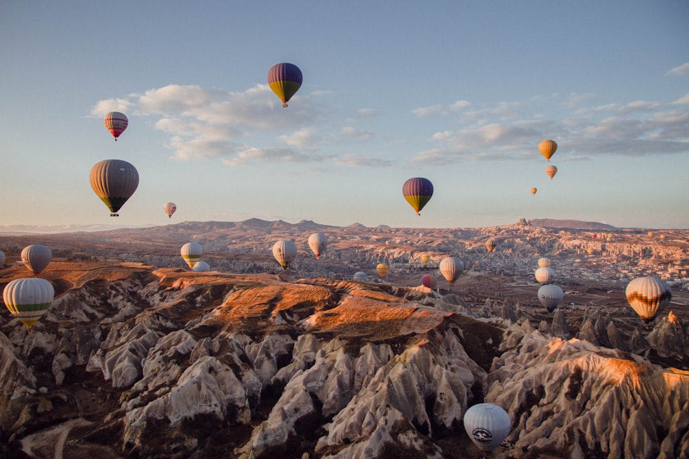 hot air balloons flying over the mountains during daytime