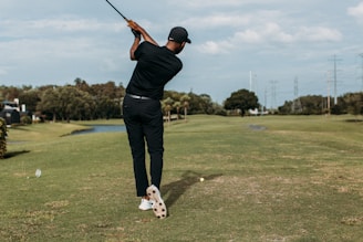 man in black shirt and black pants playing golf during daytime