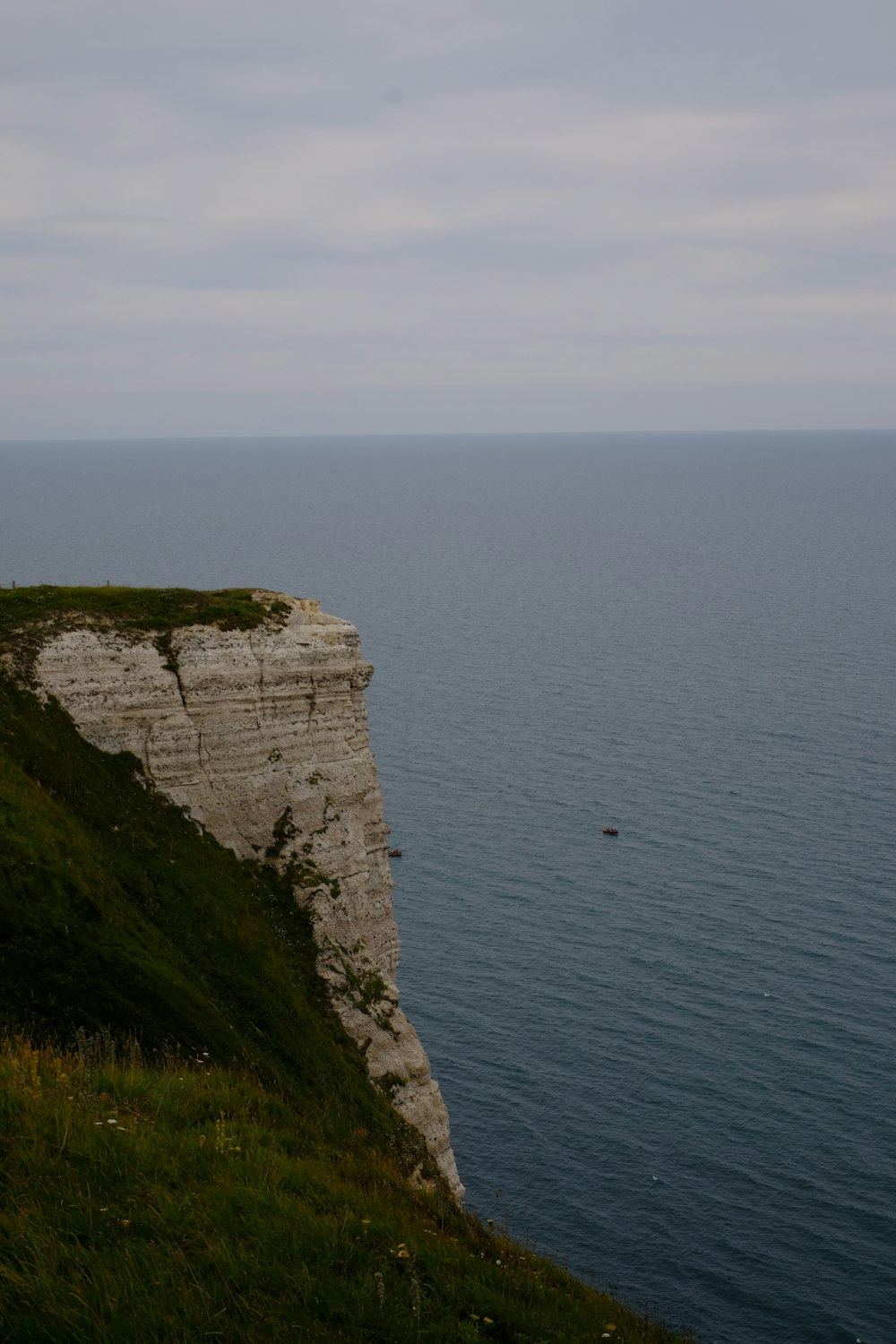 green and gray cliff beside sea during daytime