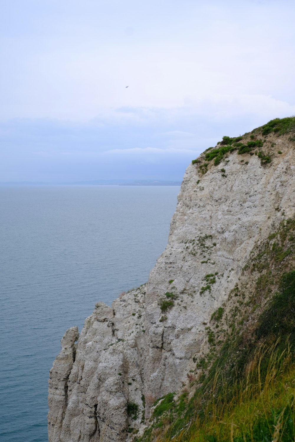 Montagna rocciosa grigia accanto al mare blu durante il giorno