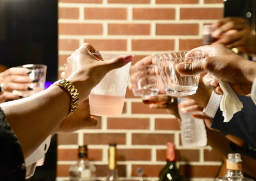 person holding clear drinking glass