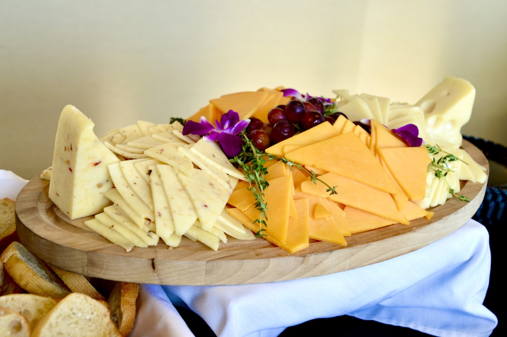 queso en rodajas sobre tabla de cortar de madera marrón