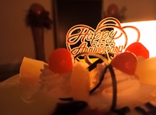 white cake with red cherry on top