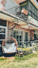 A cozy hanging chair with cushions set up on a patio.