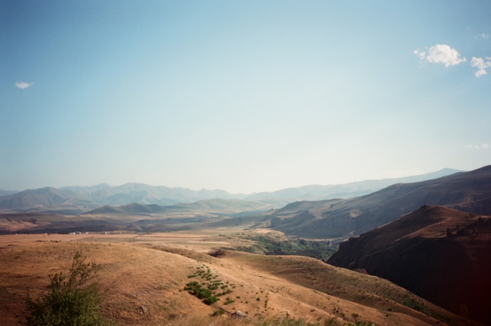 brown and green mountains under white sky during daytime