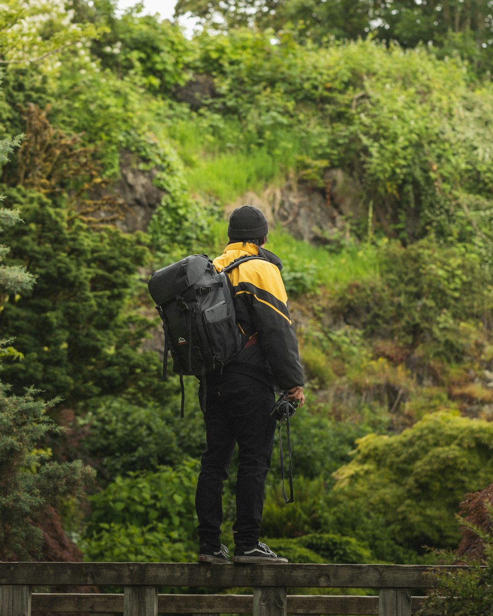 man in black and yellow backpack walking on forest during daytime