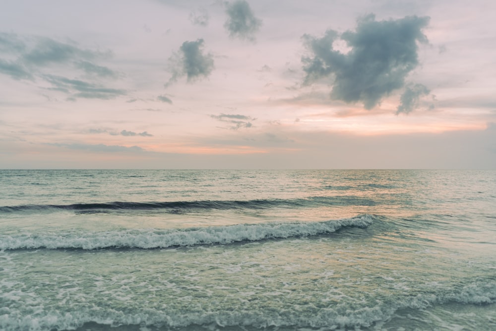 ocean waves under cloudy sky during daytime